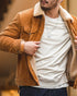 Man pulling open a tan corduroy barn jacket to show the cream sherpa lining, worn over a grey sweatshirt